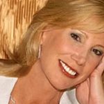 Janet Elway smiling in a close-up portrait, highlighting her elegant appearance and public image associated with Janet Elway.