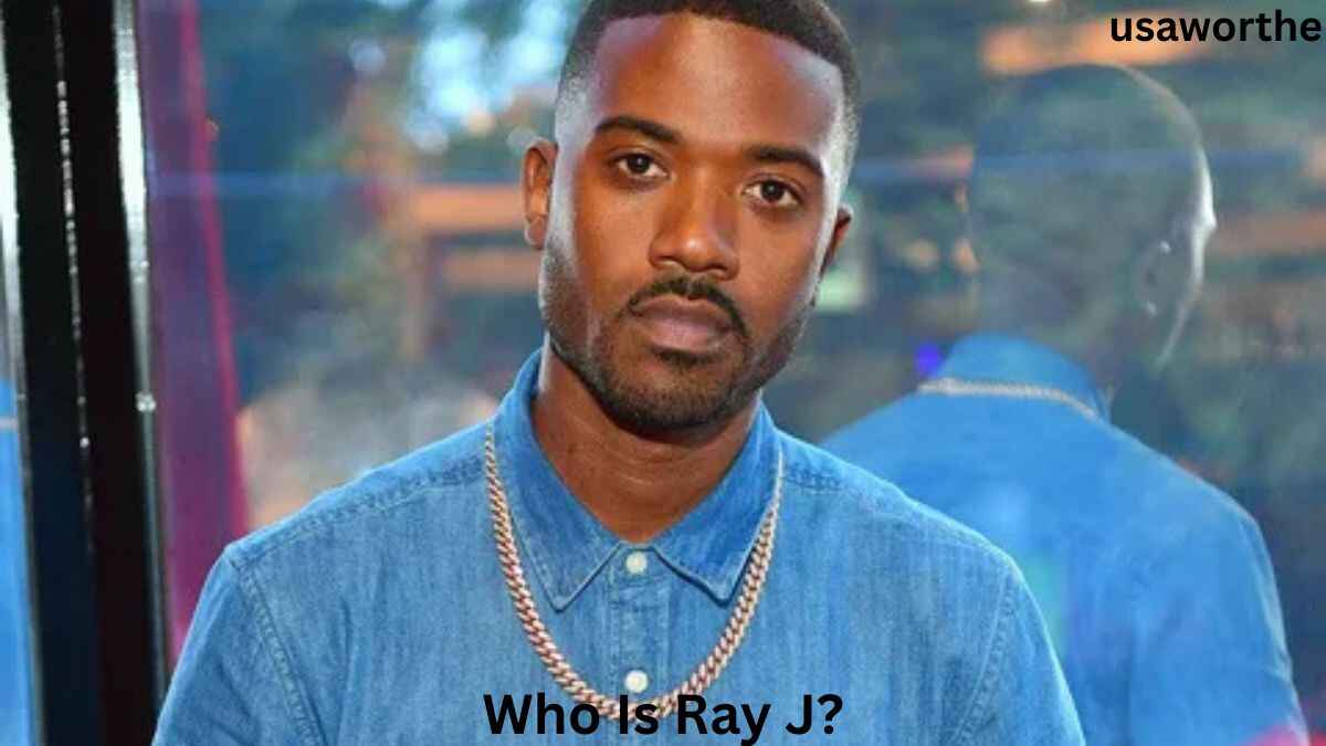 Ray J posing in a blue shirt and chain necklace, highlighting the entertainer and entrepreneur behind the question, Who Is Ray J?